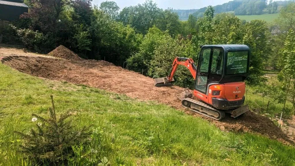 Bagger beim Abtragen einer Wiesenfläche im Oberbergischen