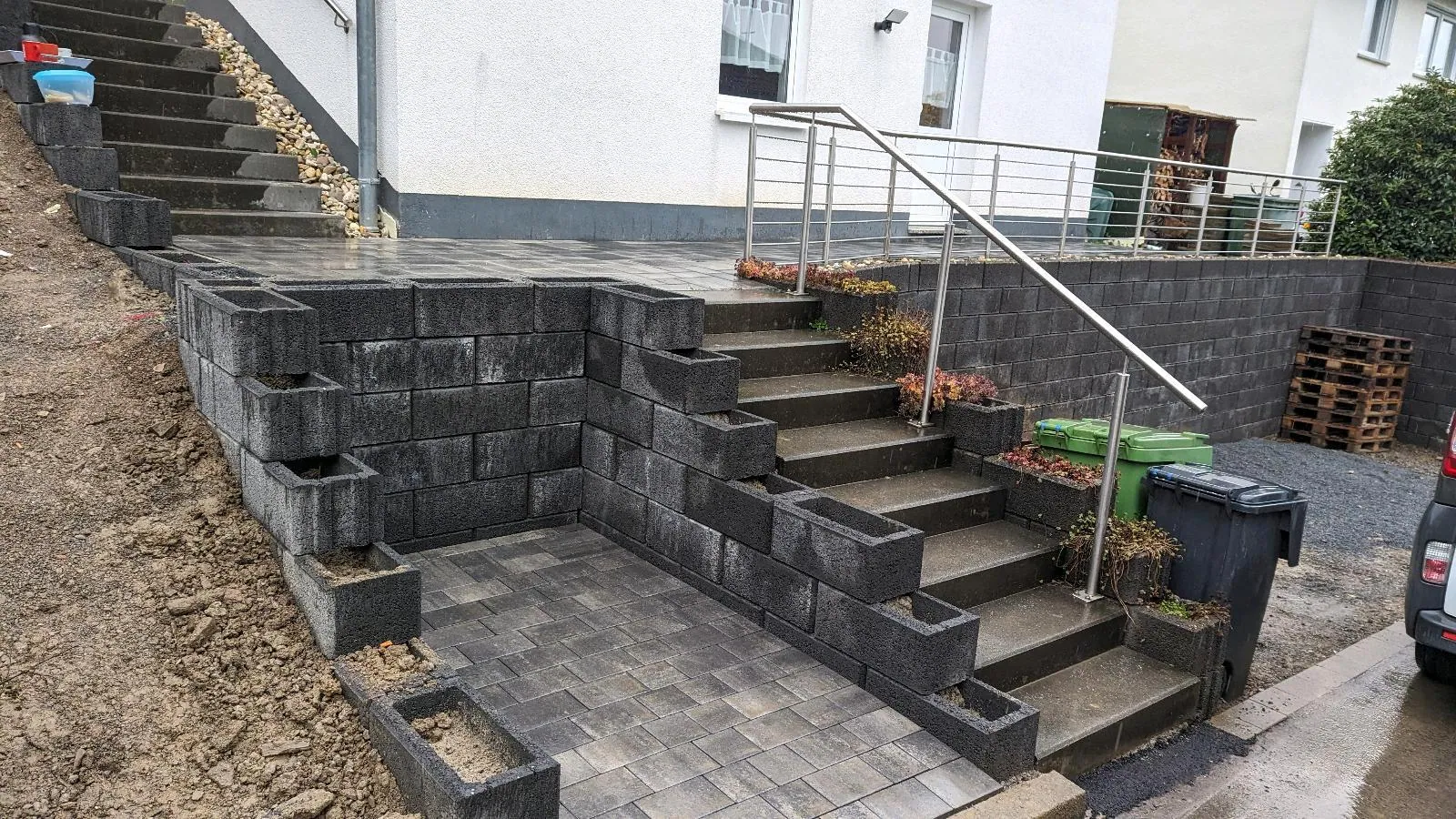 Außentreppe mit Geländer und Mauerscheiben an einer Hangsituation