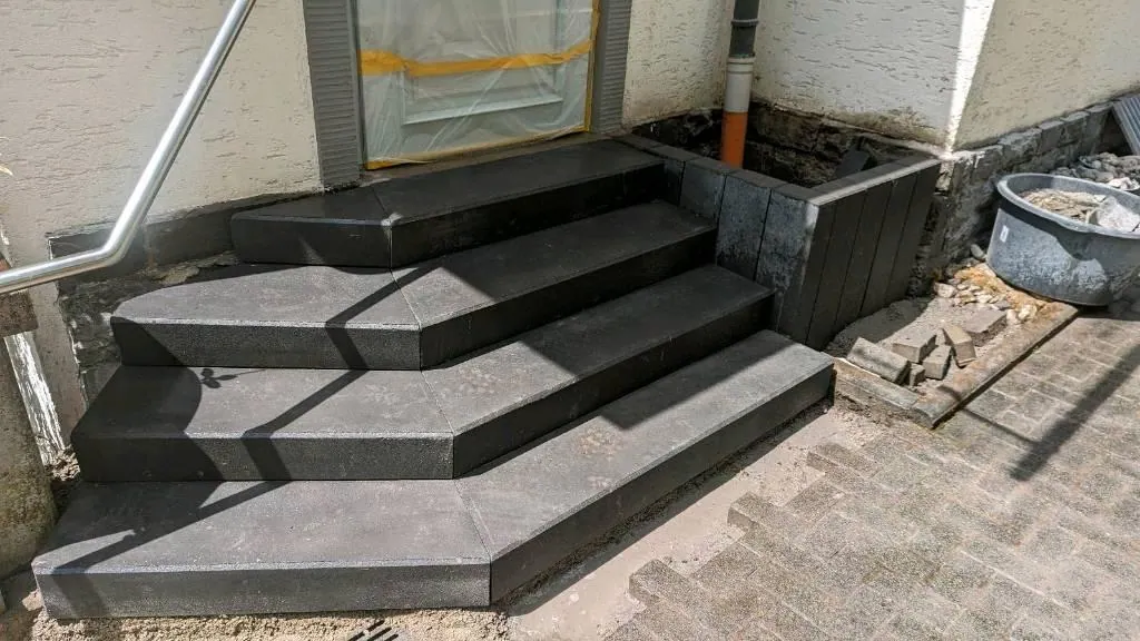 Eingangspodest mit gesetzten Blockstufen aus dunklem Naturstein
